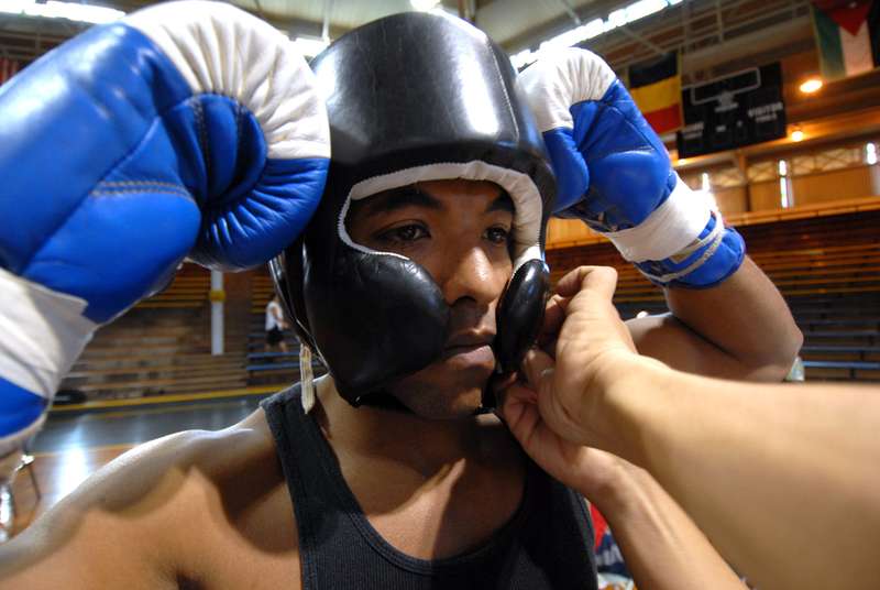 boxeur qui s'equipe avec casque de boxe avant combat